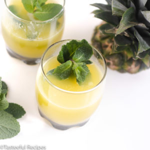 Angled shot of two glasses of pineapple mint iced tea