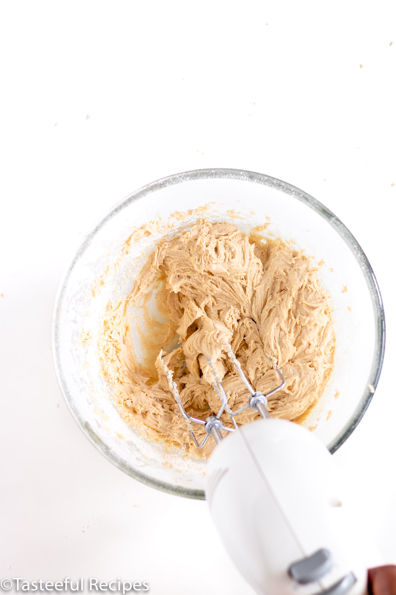 Overhead shot of vanilla spice cookie dough being mixed with a hand mixer