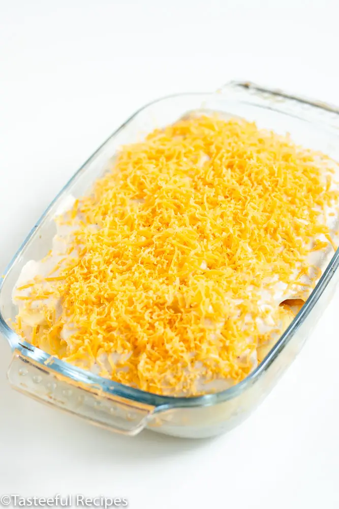 Angled shot of a baking dish with cheesy scalloped potatoes unbaked