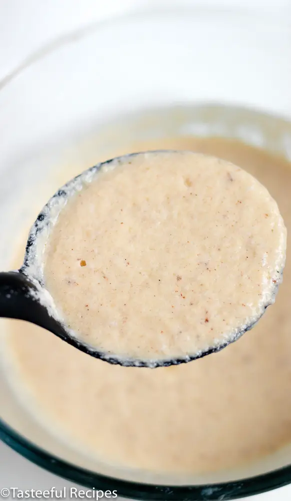 Overhead shot of a serving spoon filled with eggnog