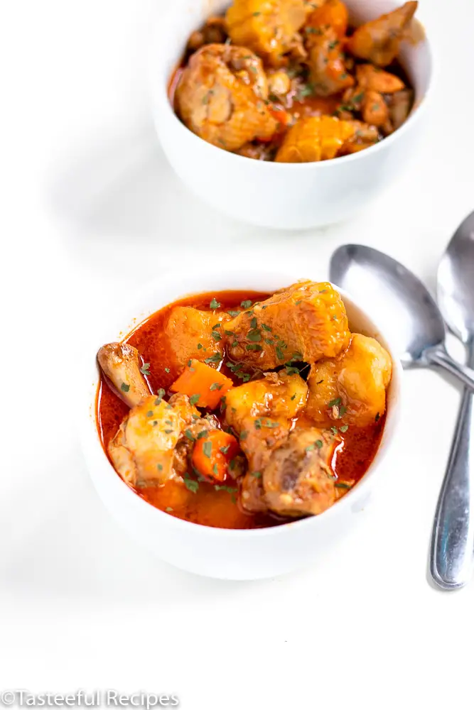 Angled shot of two bowls of caribbean chicken soup