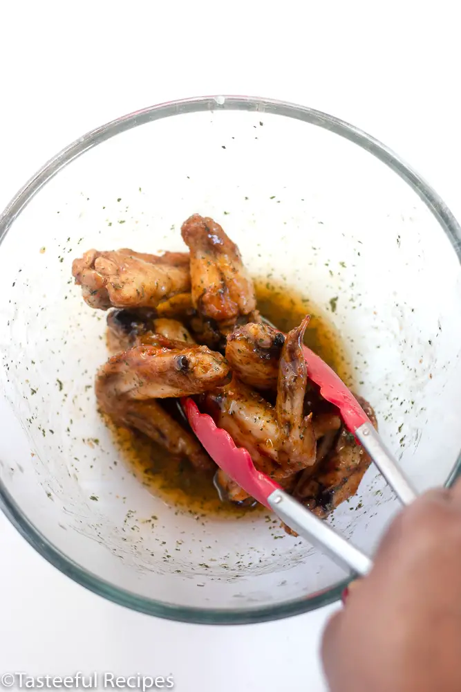 Overhead shot of wings being tossed in a bowl