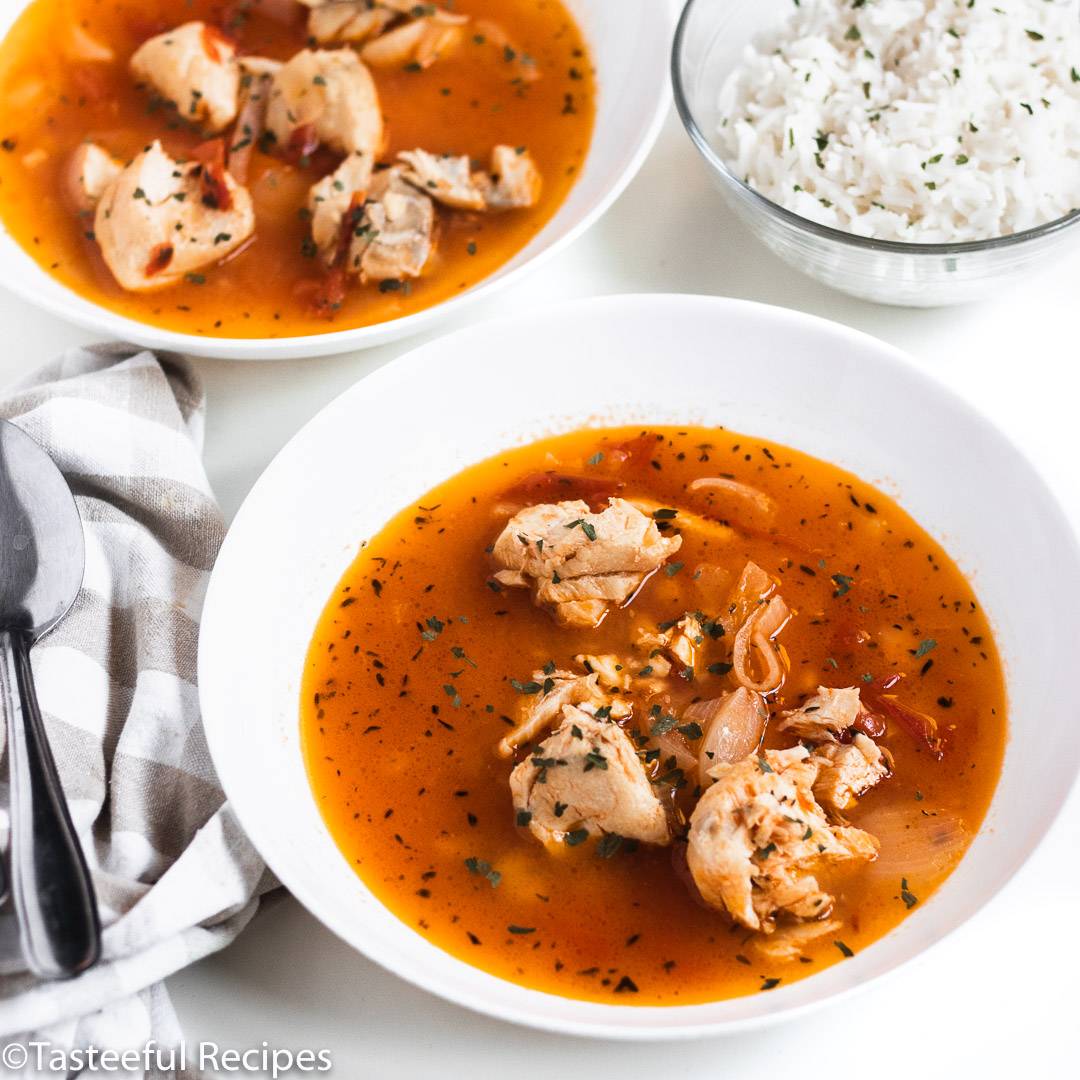 Angled shot of two bowls of tomato fish stew