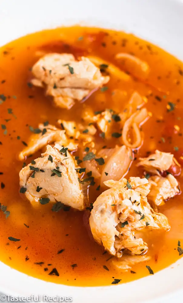 Overhead shot of a bowl of fish stew with a tomato sauce