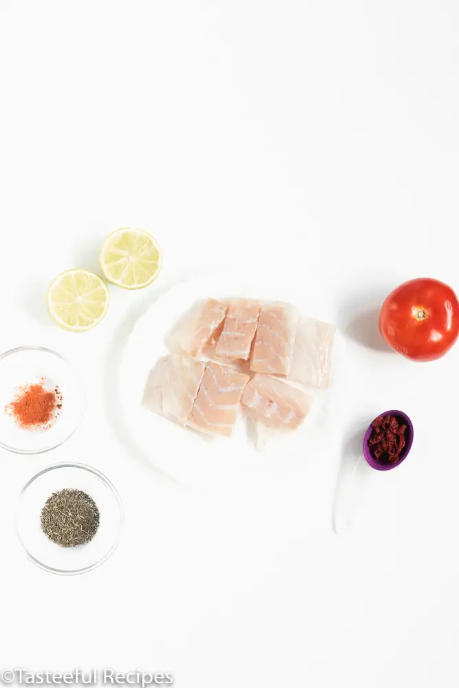 Overhead shot of fish, tomato, lime and seasonings