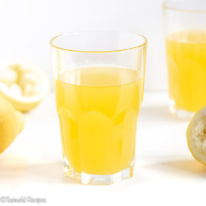 Straight on shot of a glass filled with mango lemonade