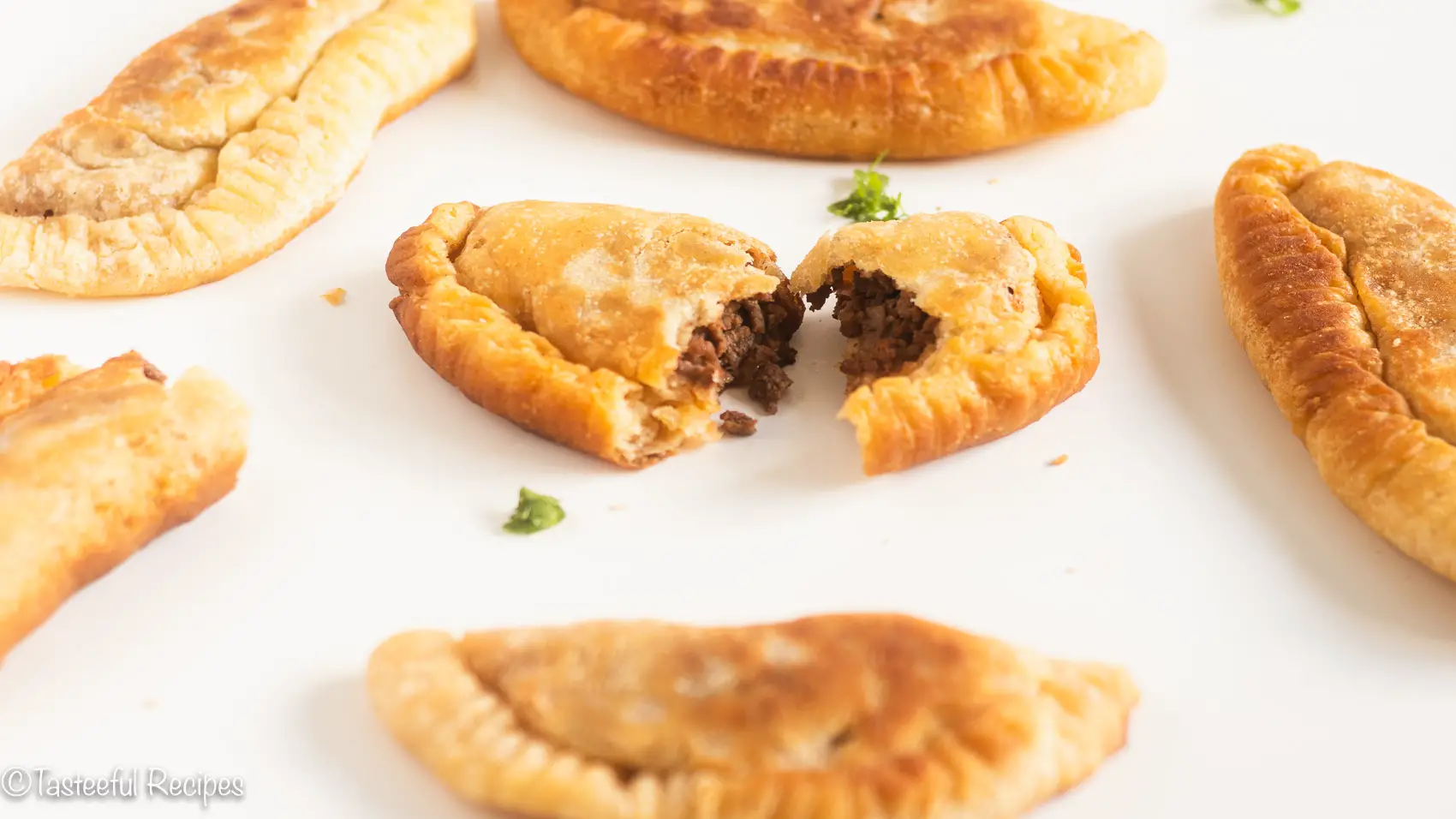 Angled shot of Caribbean beef patties on a white surface