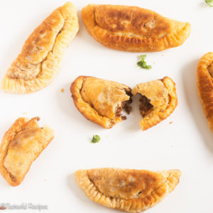 Overhead shot of Caribbean beef patties on a white surface