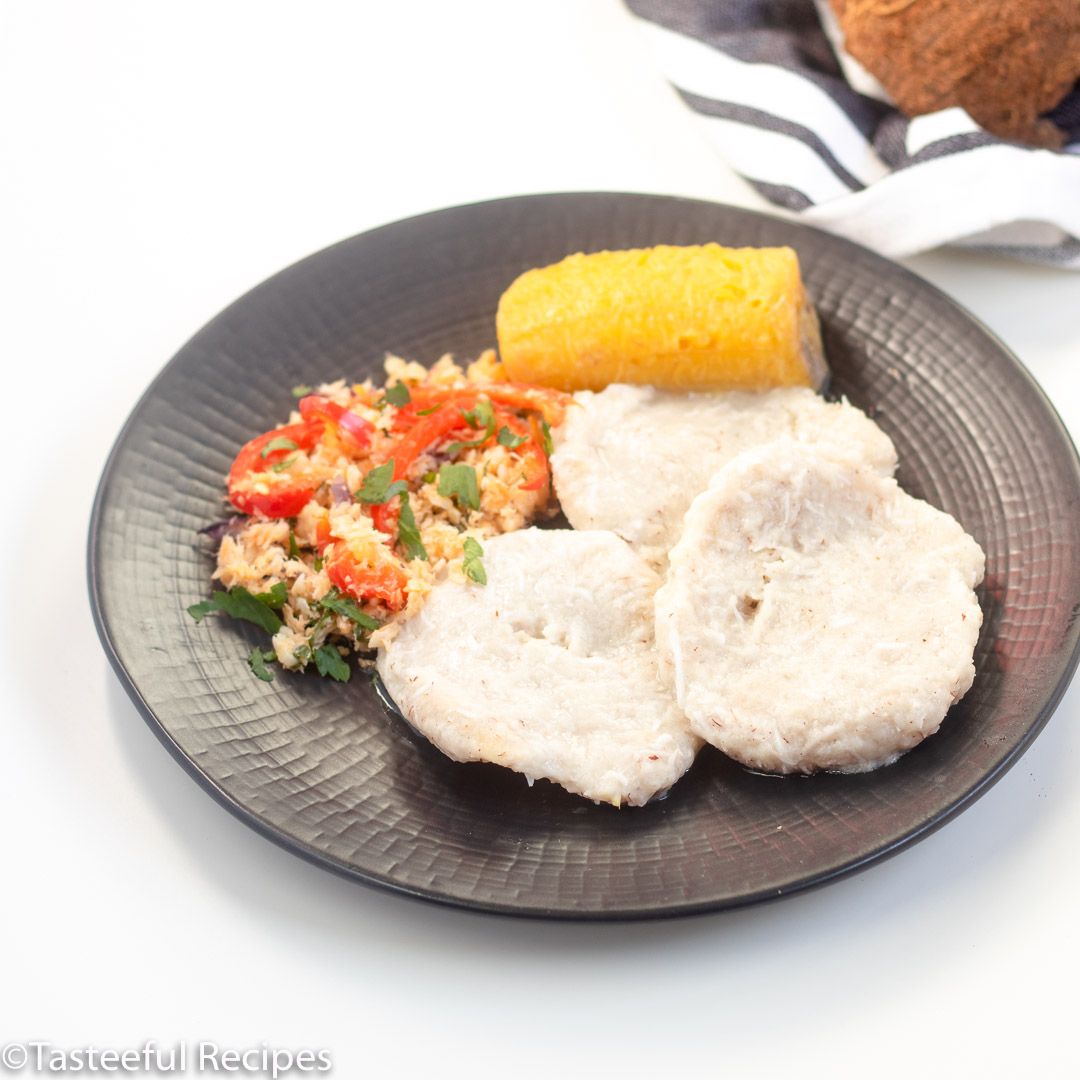 Angled shot of a plate with coconut dumplings and saltfish