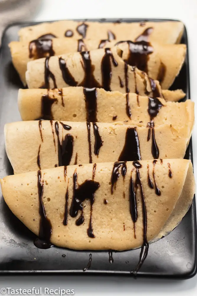 Angled shot of plantain crepes on a tray