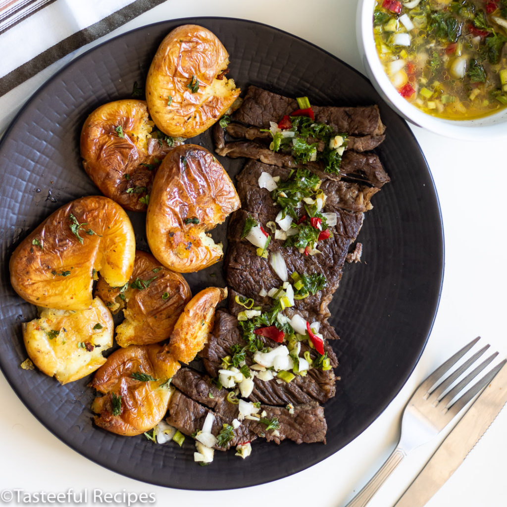 Overhead shot of steak and potatoes with a bowl of sauce chien