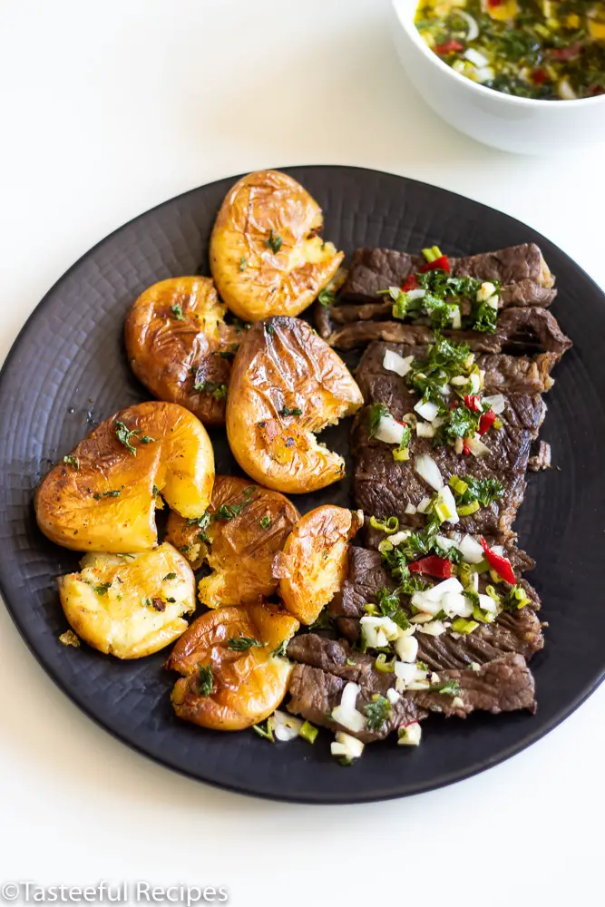 Overhead shot of steak and potatoes with a bowl of sauce chien