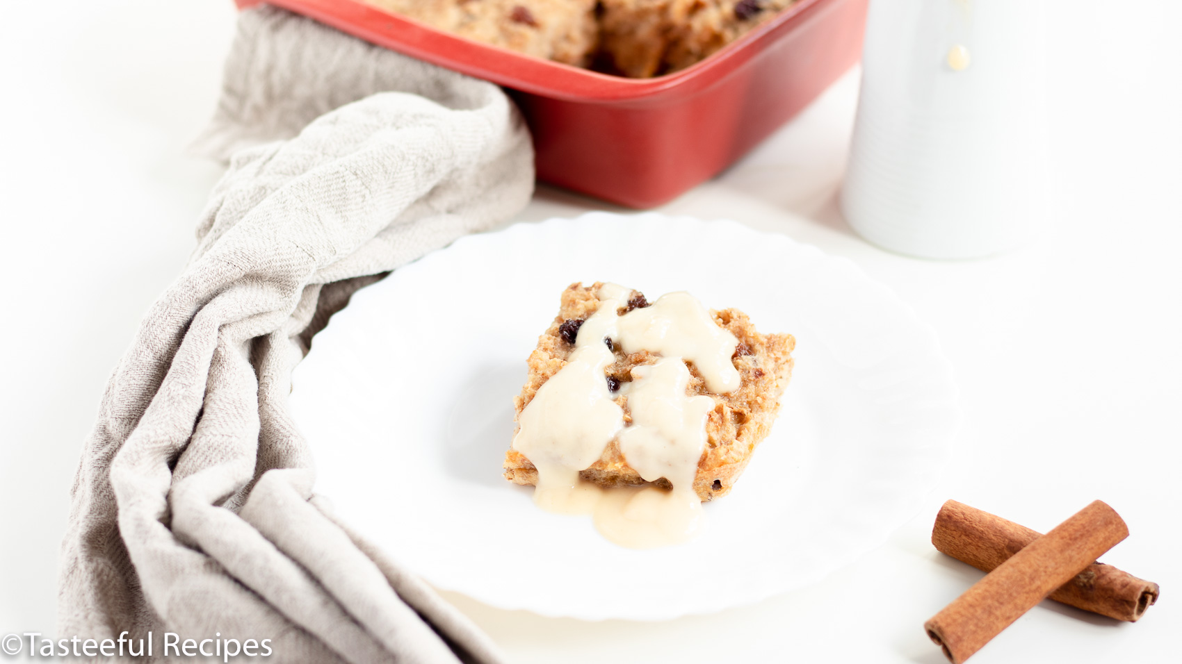 Angled shot of a slice of bread pudding topped with rum sauce