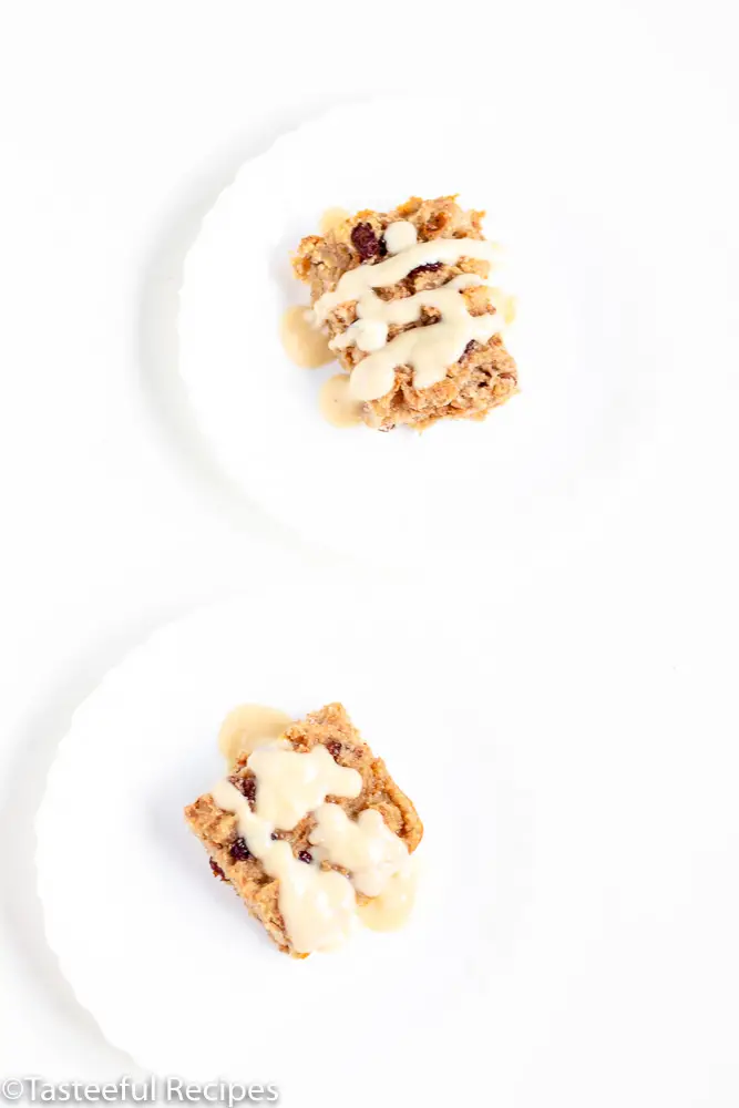 Overhead shot of two plates of caribbean-style bread pudding topped with a rum sauce