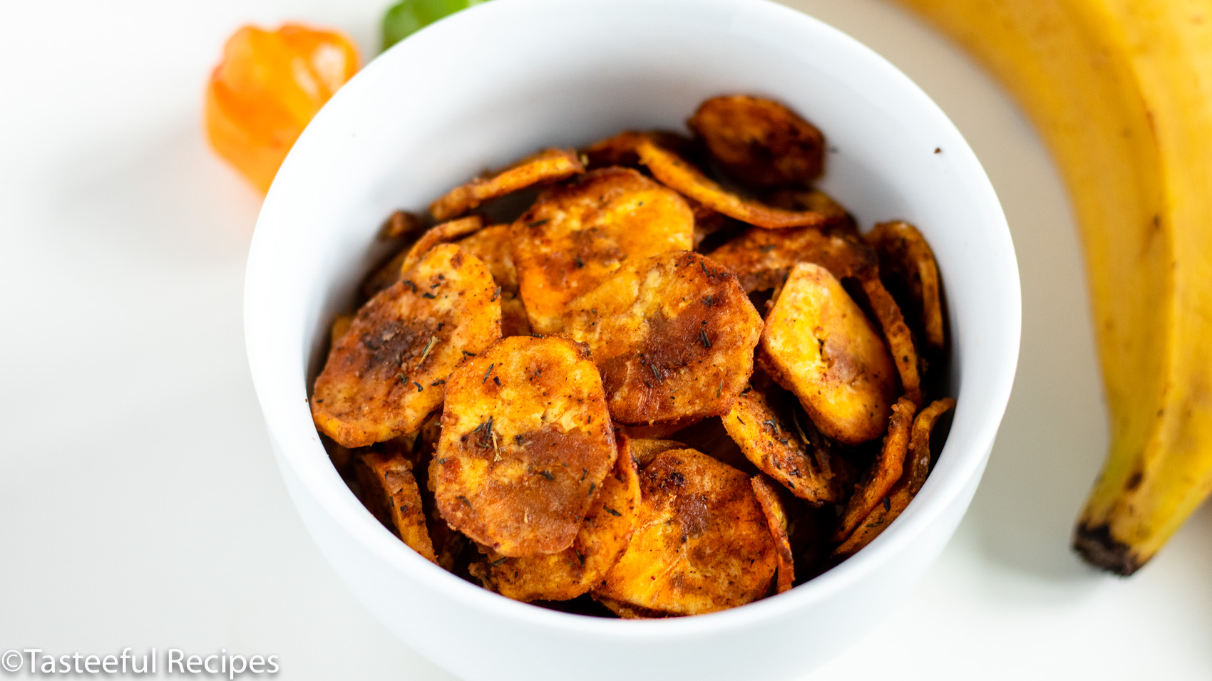 Overhead shot of a bowl of baked jerk plantain chips