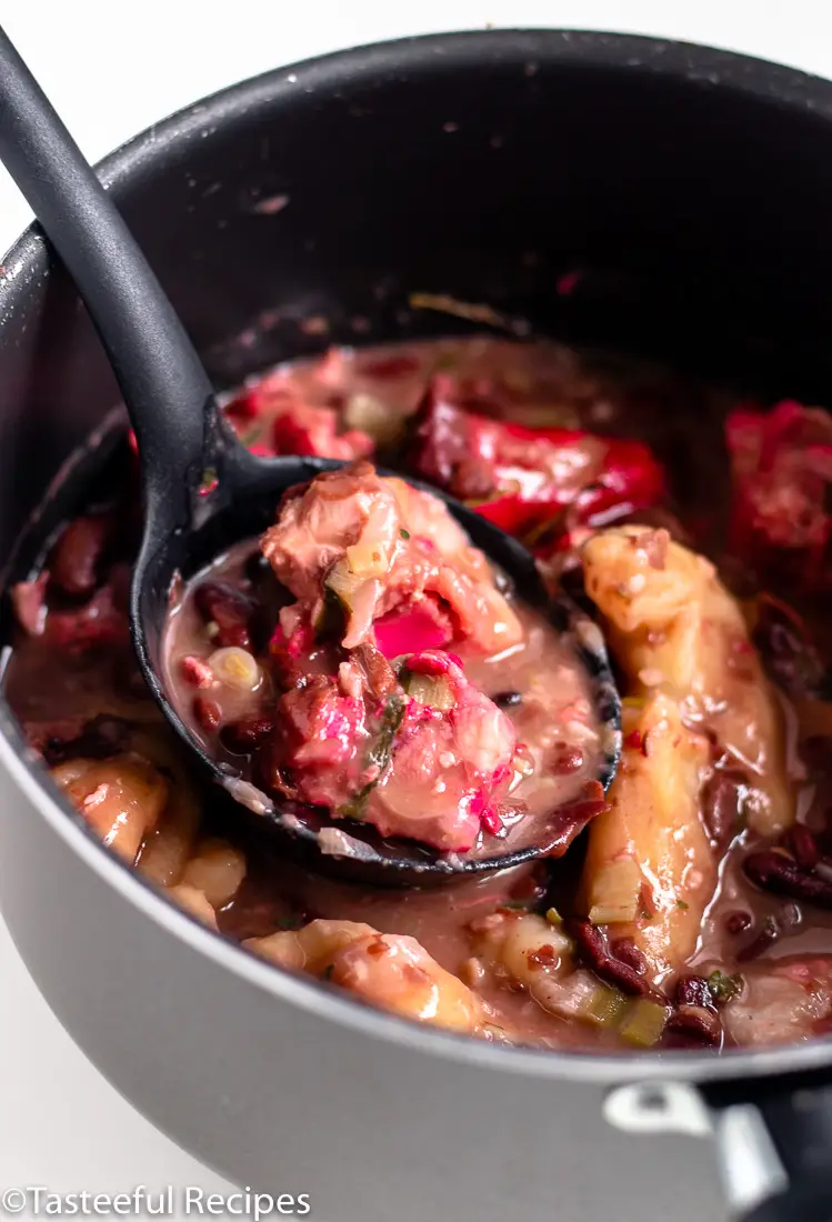 Angled shot of a pot of pigtails and red beans soup