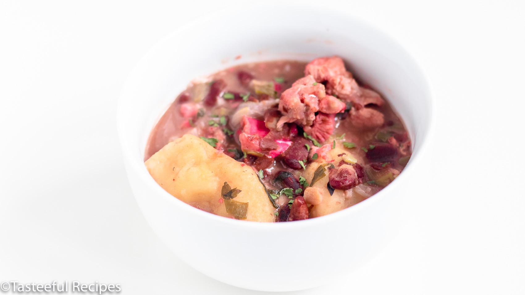 Angled shot of a pot of pigtails and red beans soup