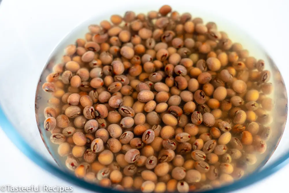 Angled shot of  bowl filled with dry pigeon peas and water