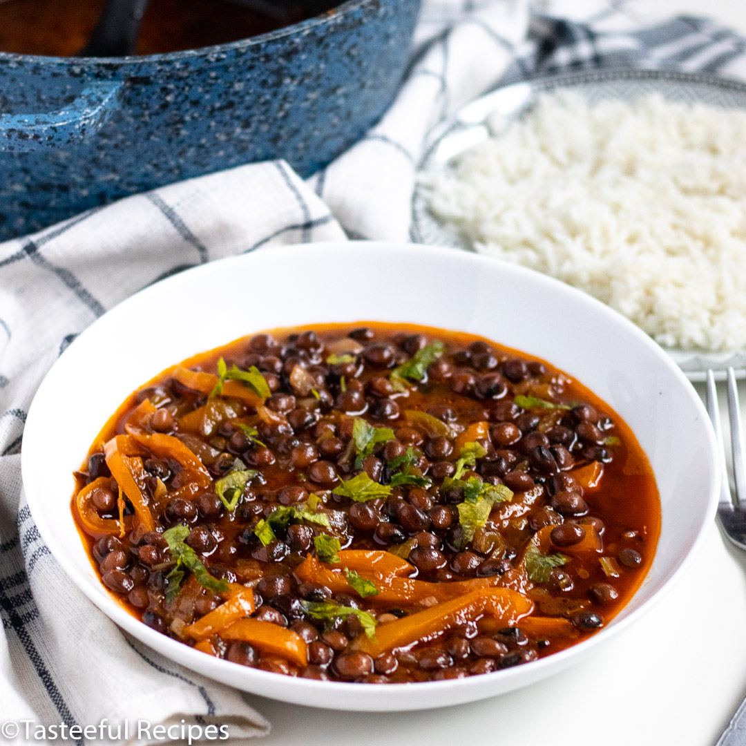 Straight on shot of a plate of Caribbean-Style stewed dry pigeon peas