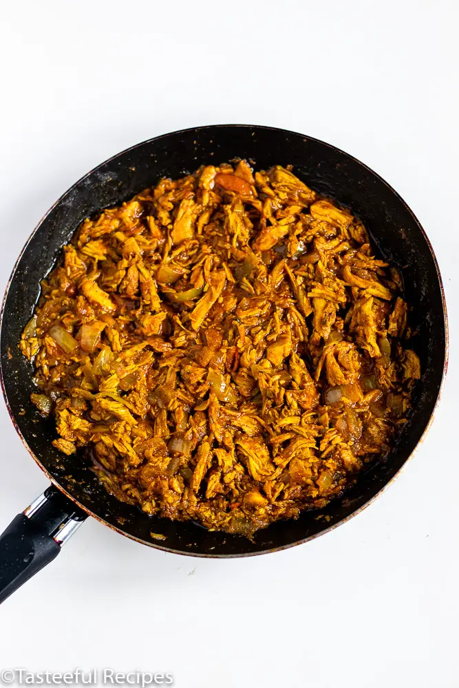 Overhead shot of a skillet filled with shredded curry chicken