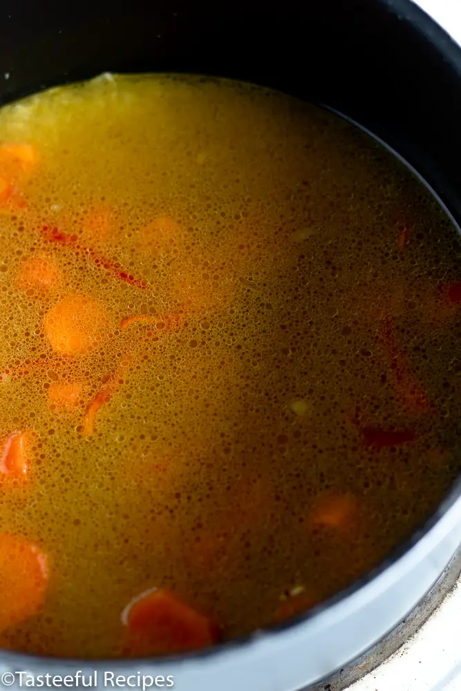 Angled shot of a pot filled with curry seasoned rice being cooked