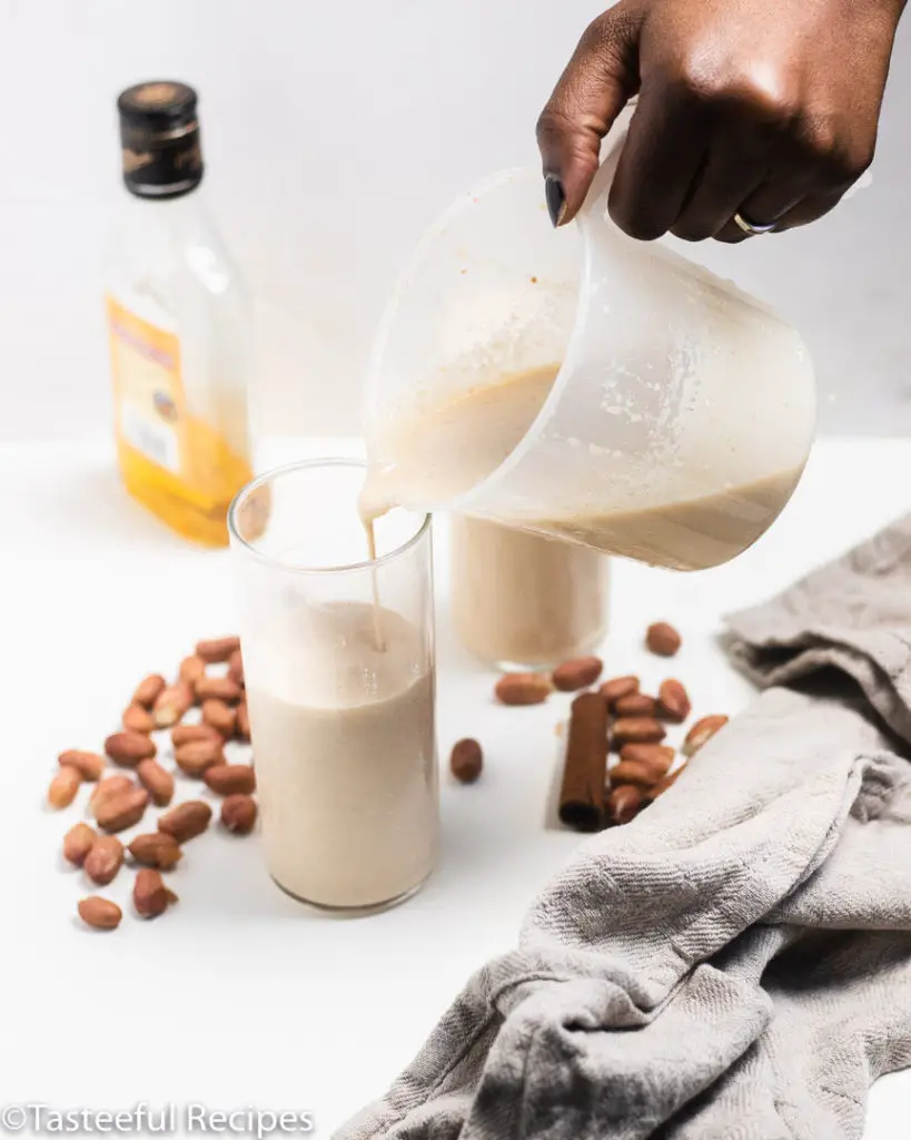 Straight on shot of peanut ponche de creme being poured into a tall glass