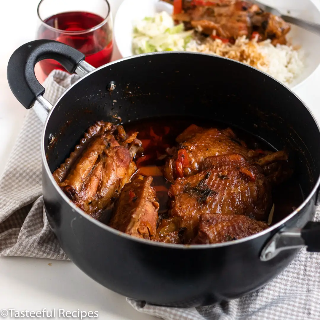 Angled shot of a pot of brown stewed turkey wings