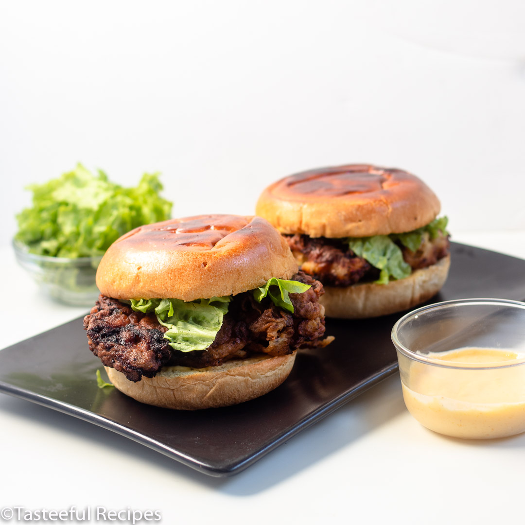 Straight on shot of two Caribbean style fried chicken sandwiches