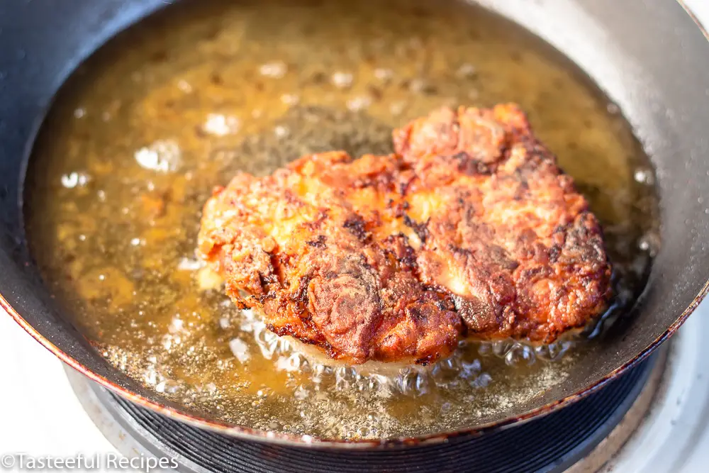 Angled shot of chicken being fried