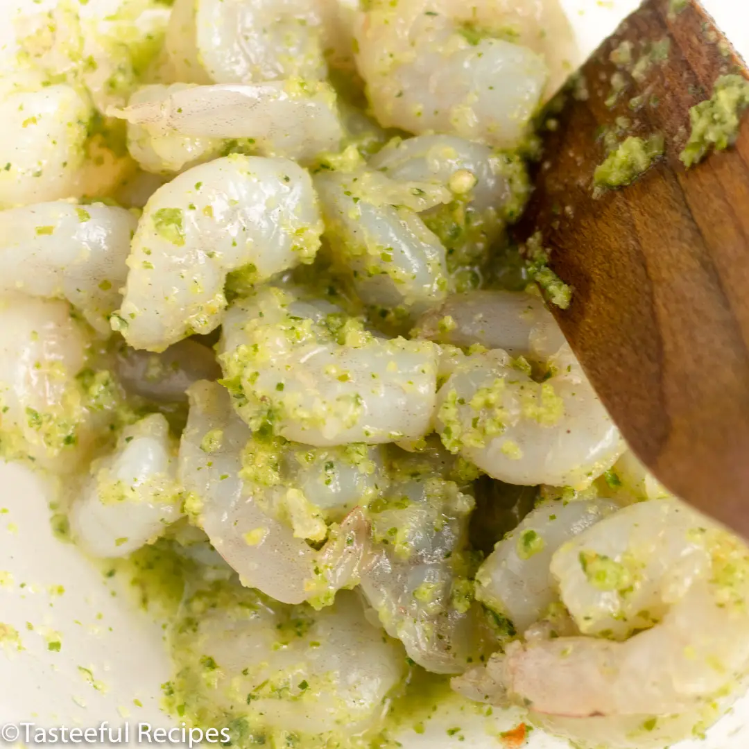 Close up shot of shrimps being seasoned with Caribbean green seasoning