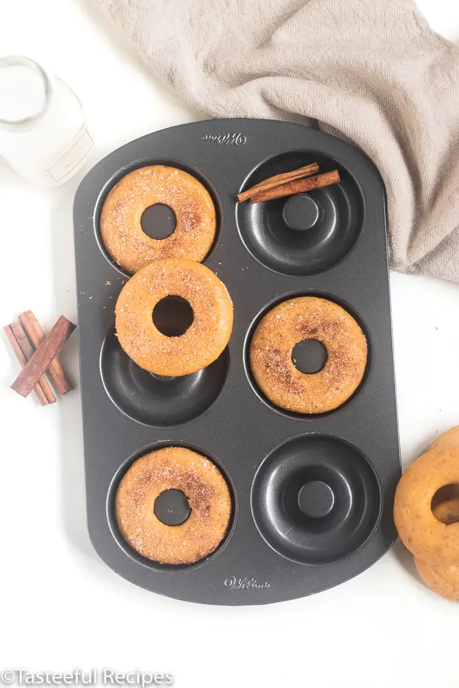 Overhead shot of baked cinnamon banana bread donuts in a donut pan