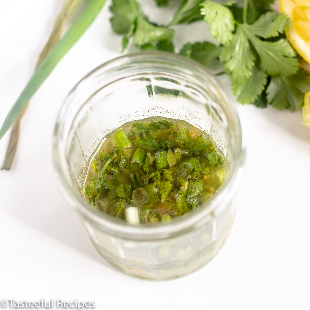 Angled shot of a jar filled with citrus salad dressing