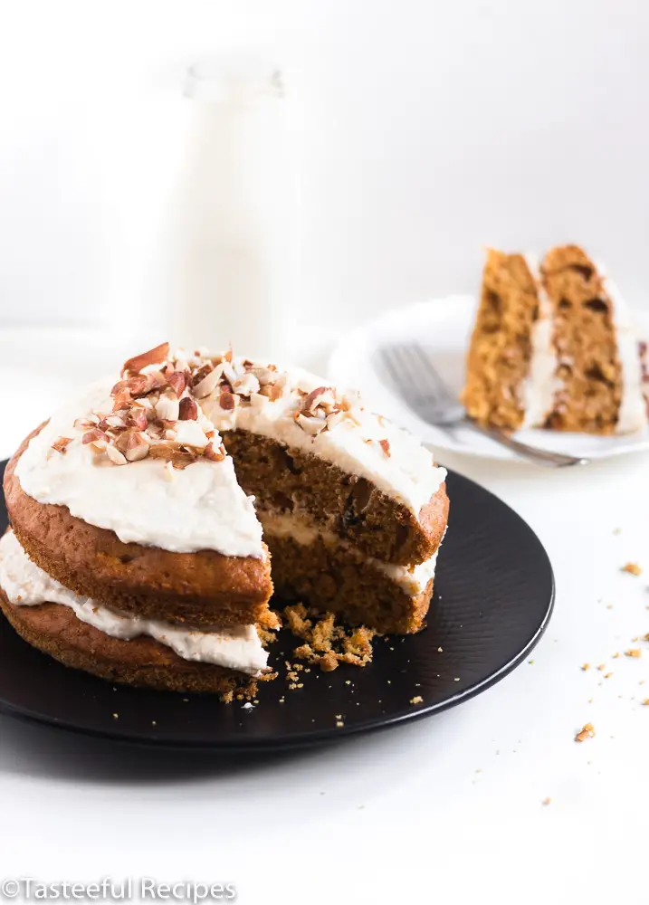 Caribbean carrot cake with cream cheese frosting and a slice in the background