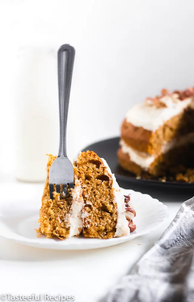 Caribbean carrot cake with cream cheese frosting with a fork in it.