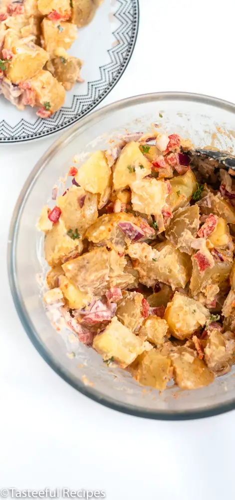 Potato salad being mixed in a bowl 