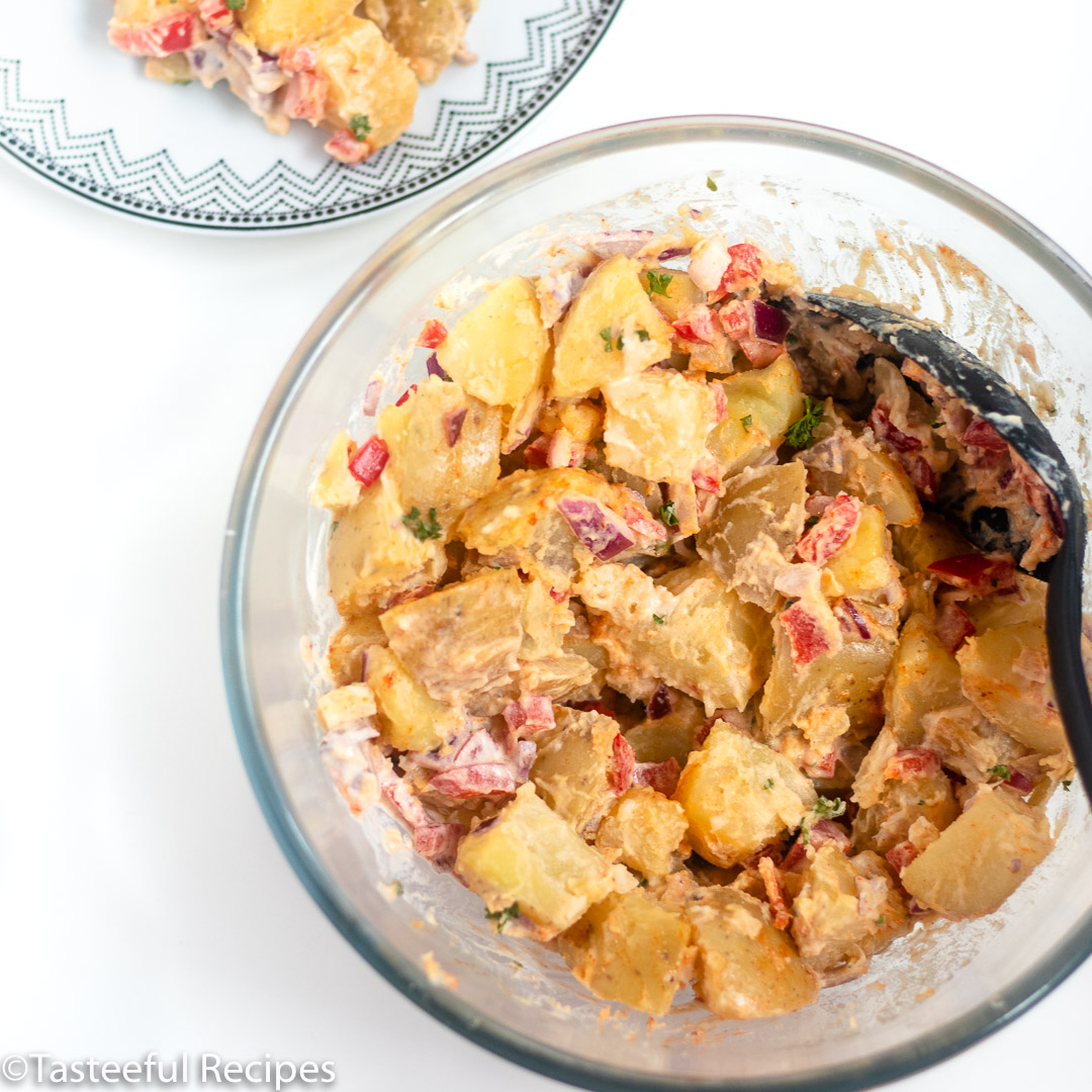 Close up of warm potato salad being mixed