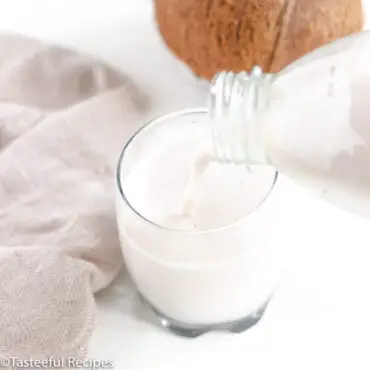 Straight on shot of homemade coconut milk being poured in a glass