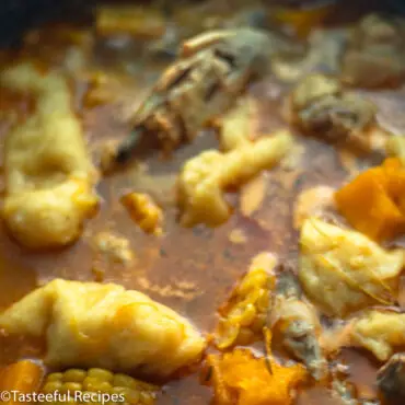 Close up shot of a pot of chicken soup with dumplings