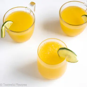 Angled shot of glasses filled with fresh homemade mango juice