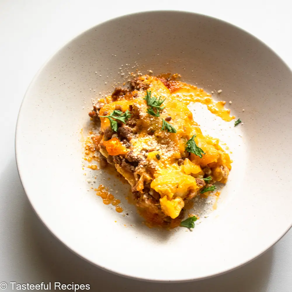 Overhead shot of a plate of Caribbean plantain lasagna topped with fresh parsley