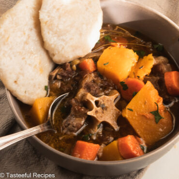 Close up shot of a bowl of oxtail soup with cassava dumplings